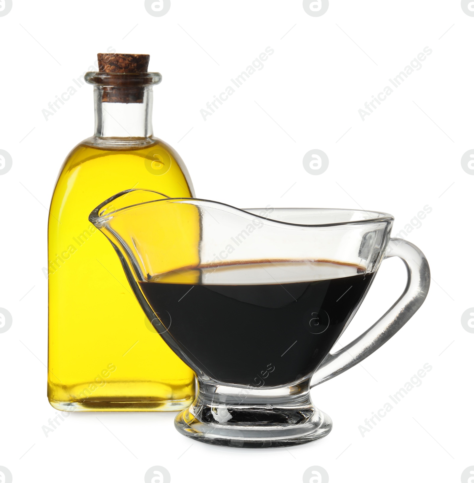 Photo of Balsamic vinegar in gravy boat, and bottle of oil isolated on white