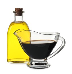 Photo of Balsamic vinegar in gravy boat, and bottle of oil isolated on white