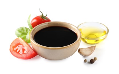 Photo of Balsamic vinegar in bowl, oil, tomatoes, basil and spices isolated on white