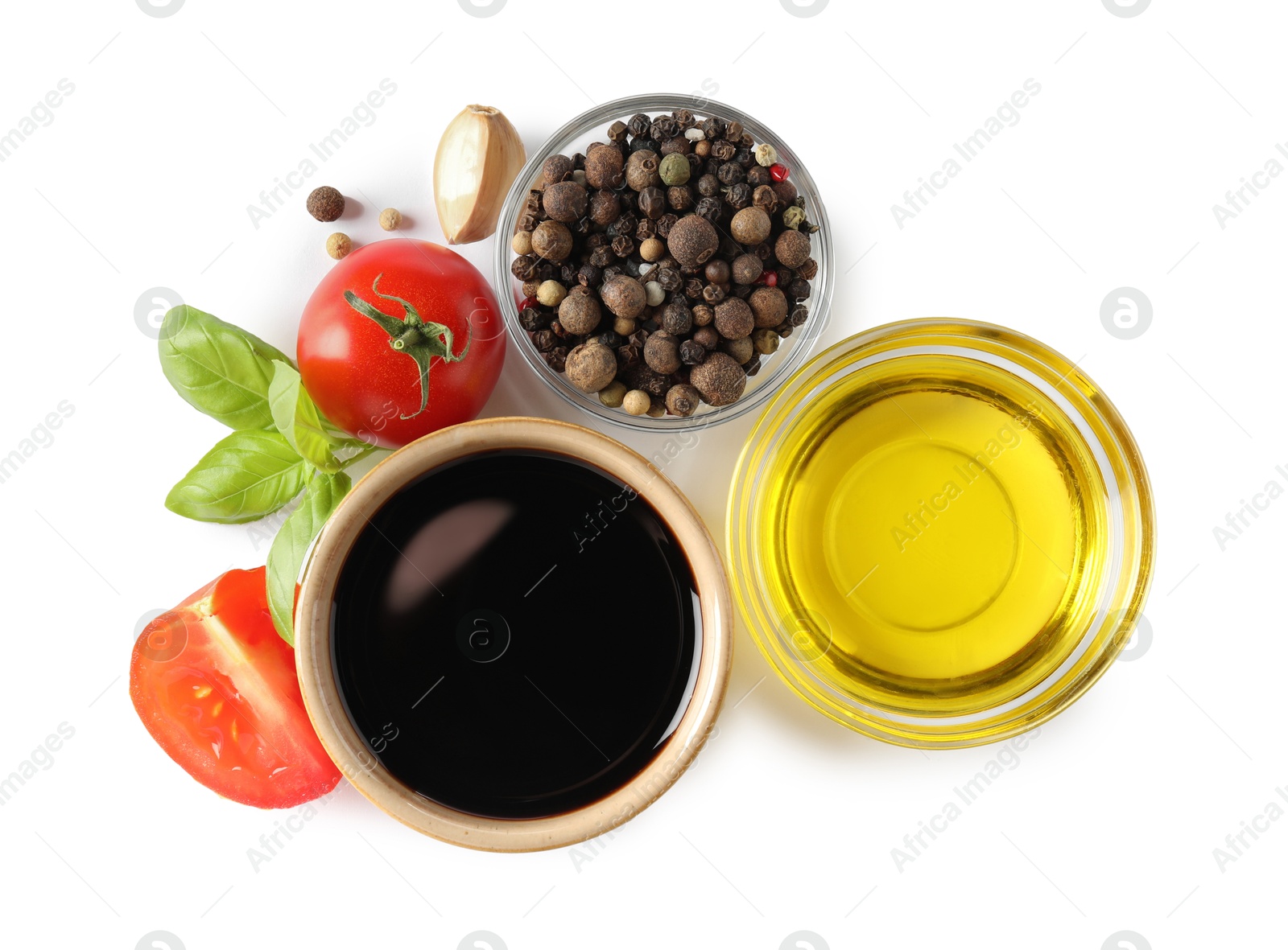 Photo of Balsamic vinegar in bowl, oil, tomatoes, basil and spices isolated on white, top view