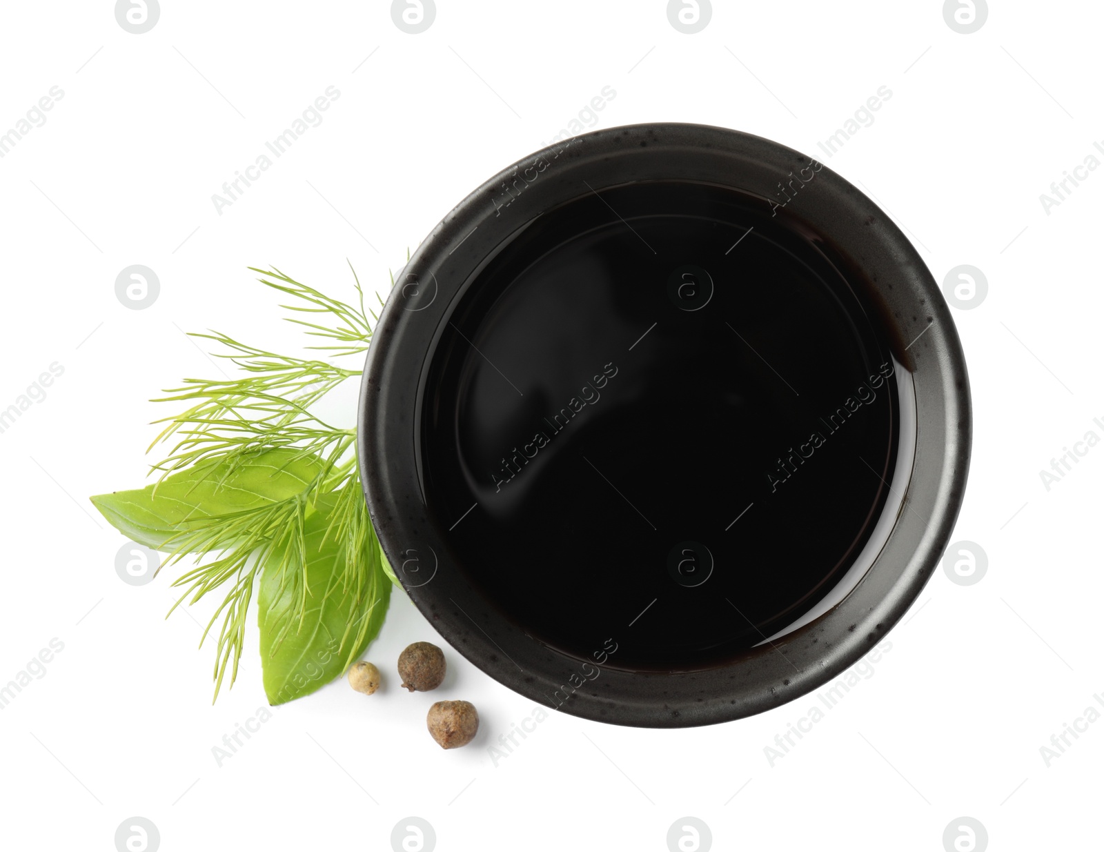 Photo of Balsamic vinegar in bowl, herbs and spices isolated on white, top view