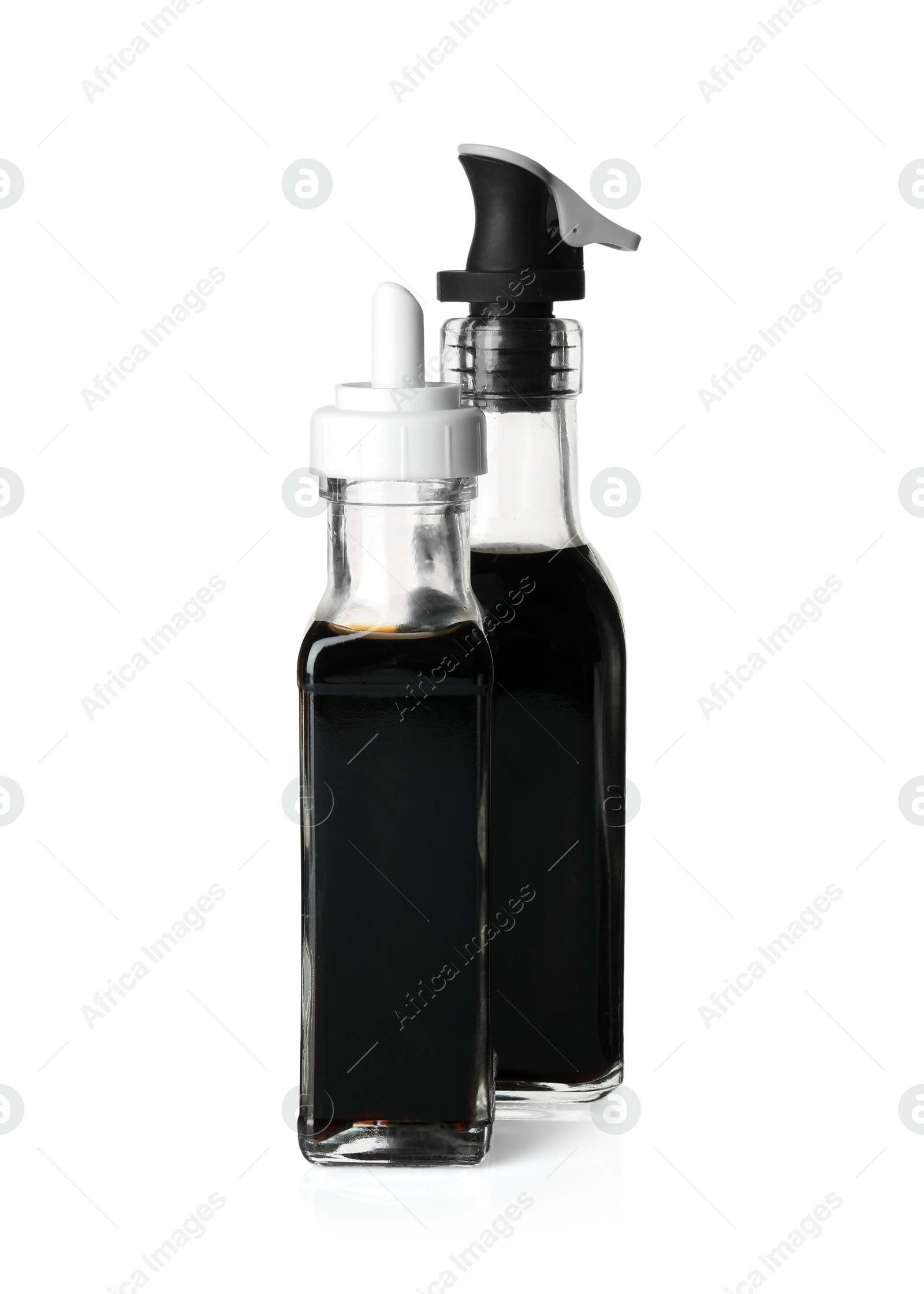 Photo of Balsamic vinegar in bottles isolated on white