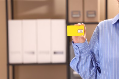 Photo of Woman holding SIM card indoors, closeup. Space for text