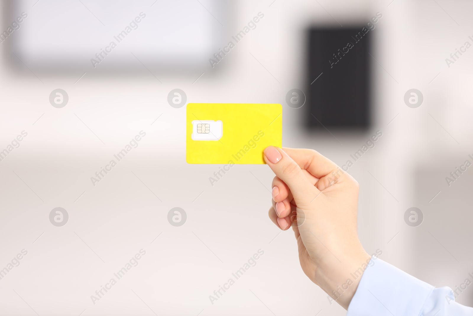 Photo of Woman holding modern SIM card indoors, closeup