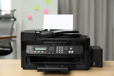 Photo of Modern printer with paper on wooden table in office