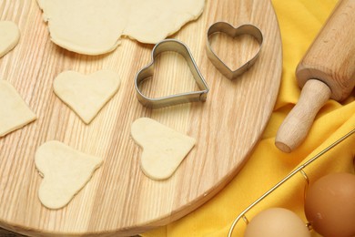 Photo of Raw dough, cookie cutters, rolling pin and eggs on table, above view