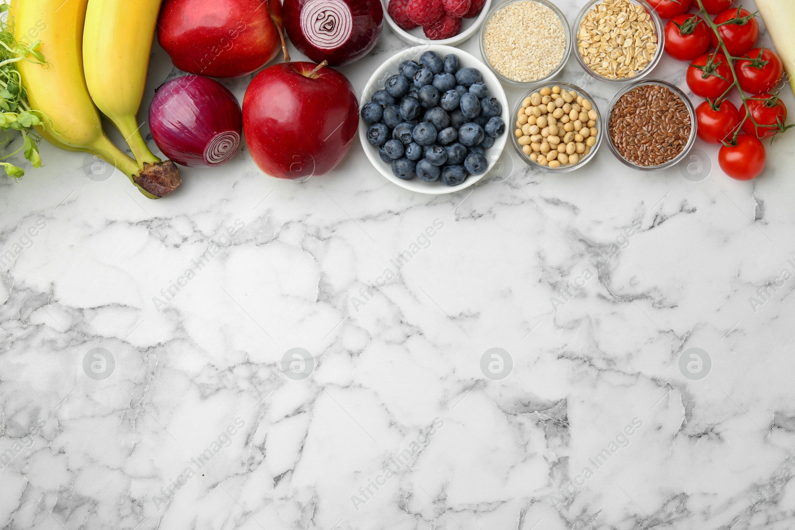 Photo of Different fresh products on white marble table, flat lay and space for text. Source of prebiotics