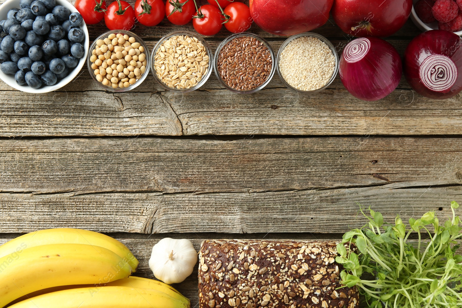 Photo of Different fresh products on wooden table, flat lay and space for text. Source of prebiotics