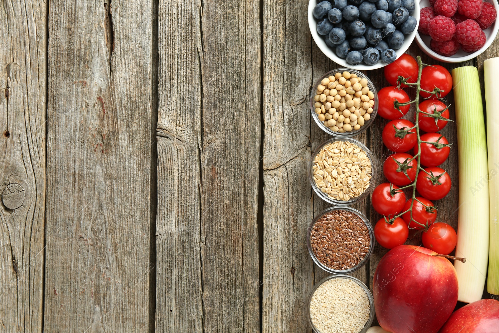 Photo of Different fresh products on wooden table, flat lay and space for text. Source of prebiotics