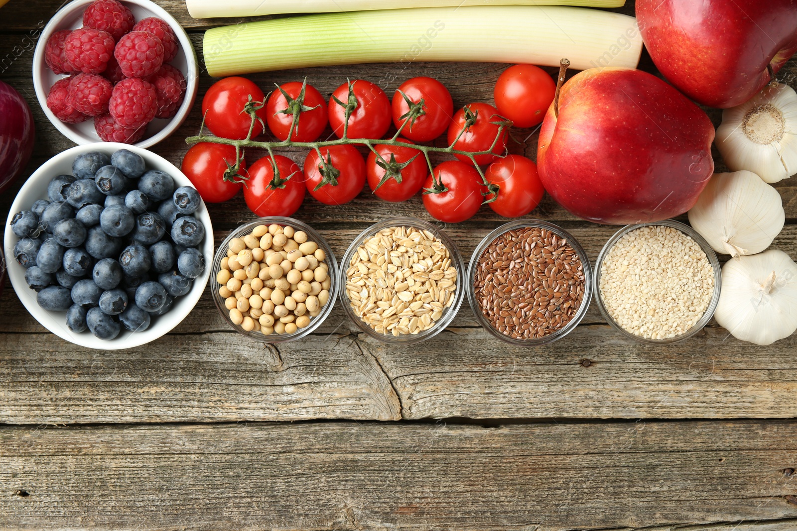 Photo of Different fresh products on wooden table, flat lay and space for text. Source of prebiotics