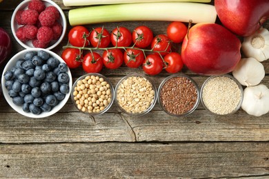 Photo of Different fresh products on wooden table, flat lay and space for text. Source of prebiotics