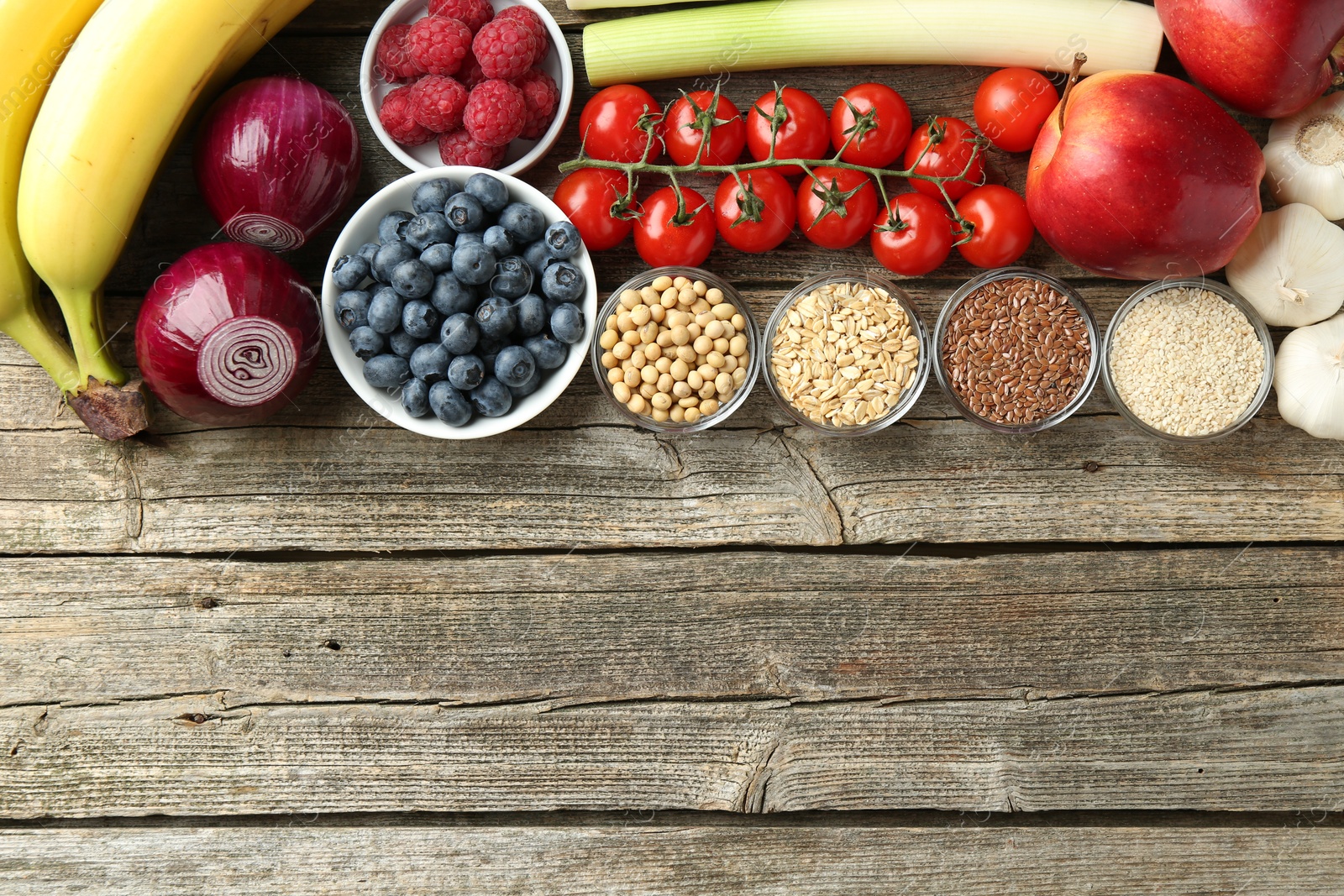 Photo of Different fresh products on wooden table, flat lay and space for text. Source of prebiotics