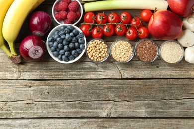 Different fresh products on wooden table, flat lay and space for text. Source of prebiotics