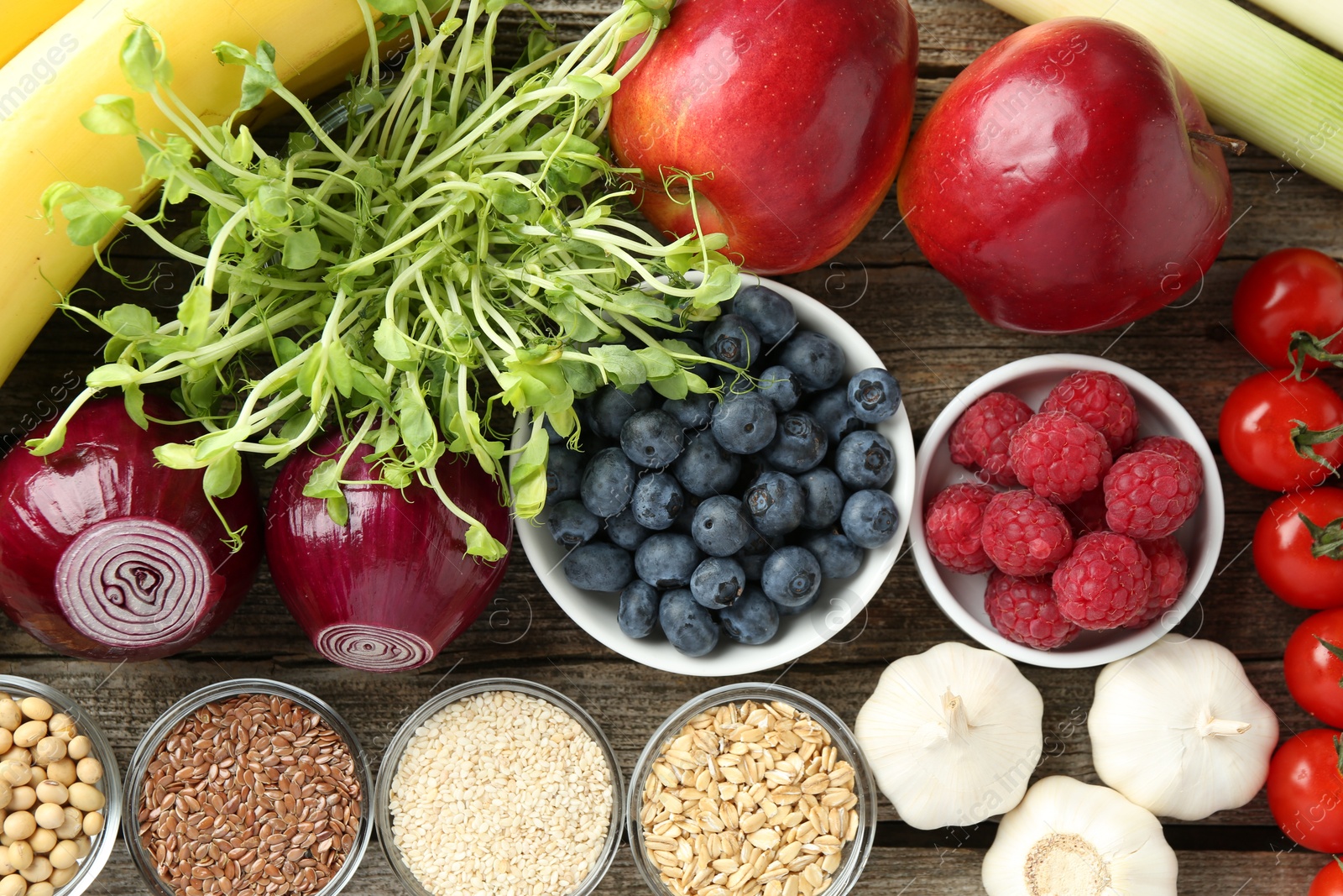 Photo of Different fresh products on wooden table, flat lay. Source of prebiotics