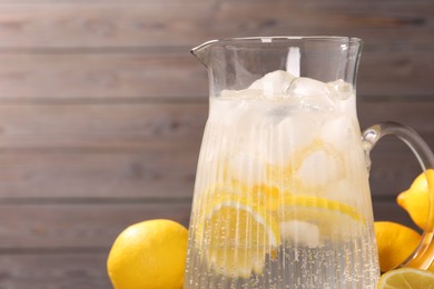 Photo of Freshly made lemonade in jug on table, closeup. Space for text