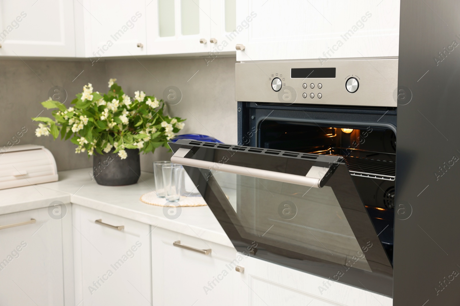 Photo of Open electric oven in kitchen. Cooking appliance