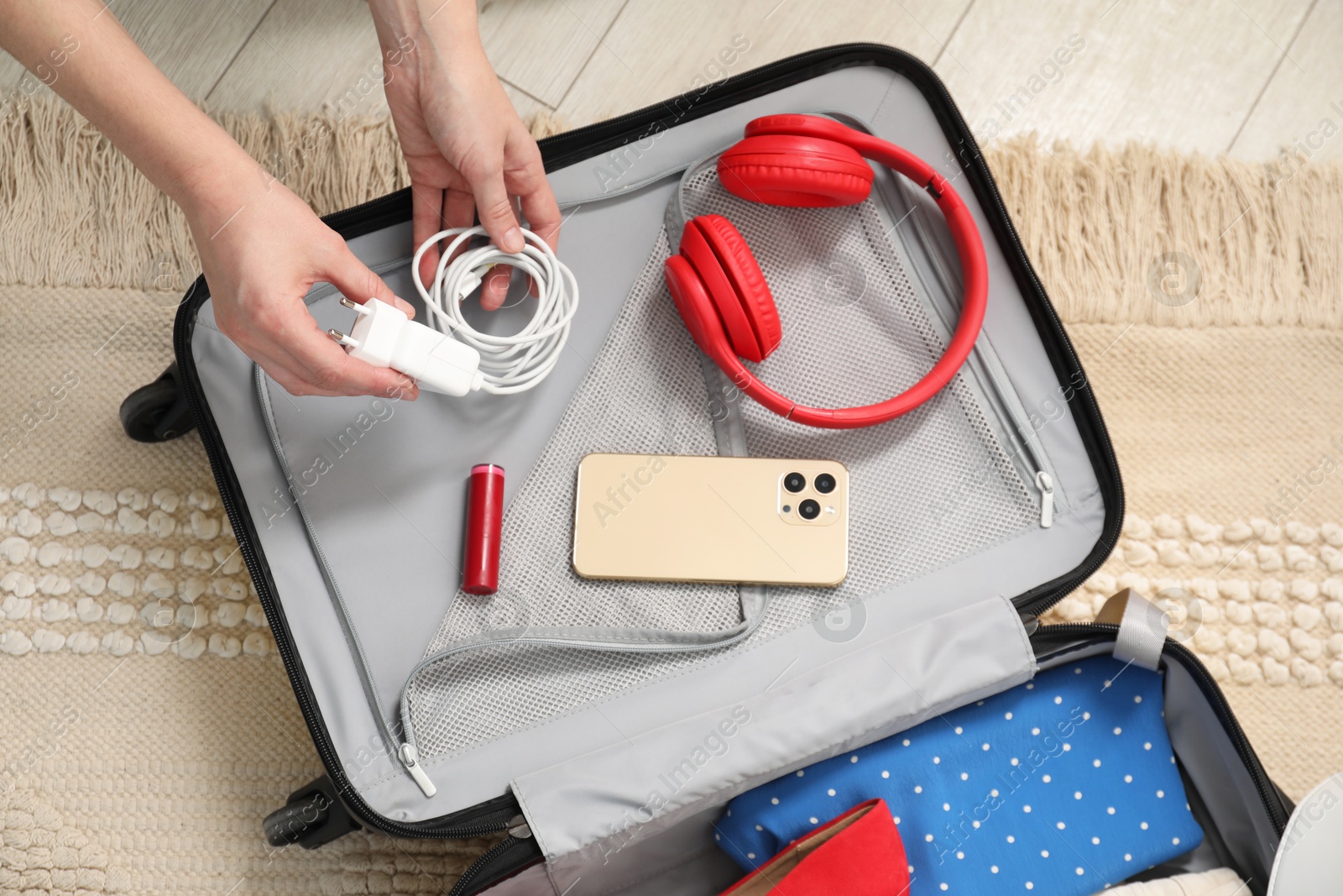 Photo of Woman packing suitcase for trip at home, top view