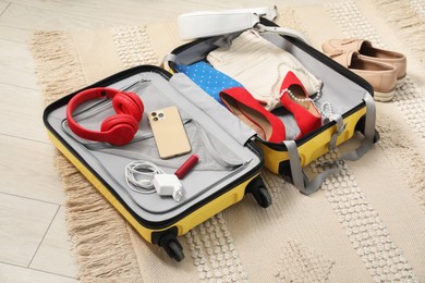 Open suitcase with traveler's belongings on floor