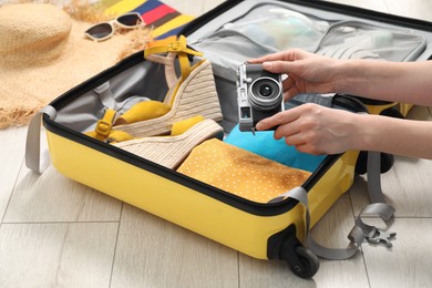 Woman packing suitcase for trip at home, closeup