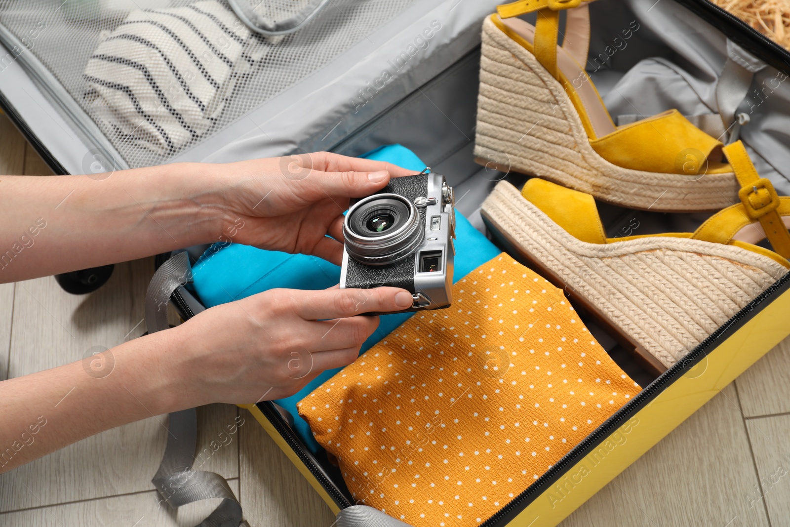 Photo of Woman packing suitcase for trip at home, closeup