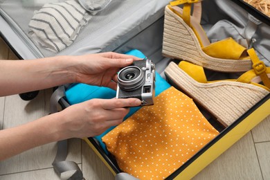 Photo of Woman packing suitcase for trip at home, closeup