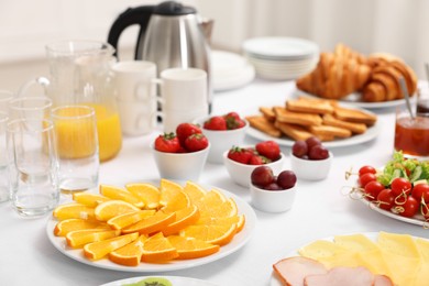 Different meals served on white table indoors, closeup. Buffet menu