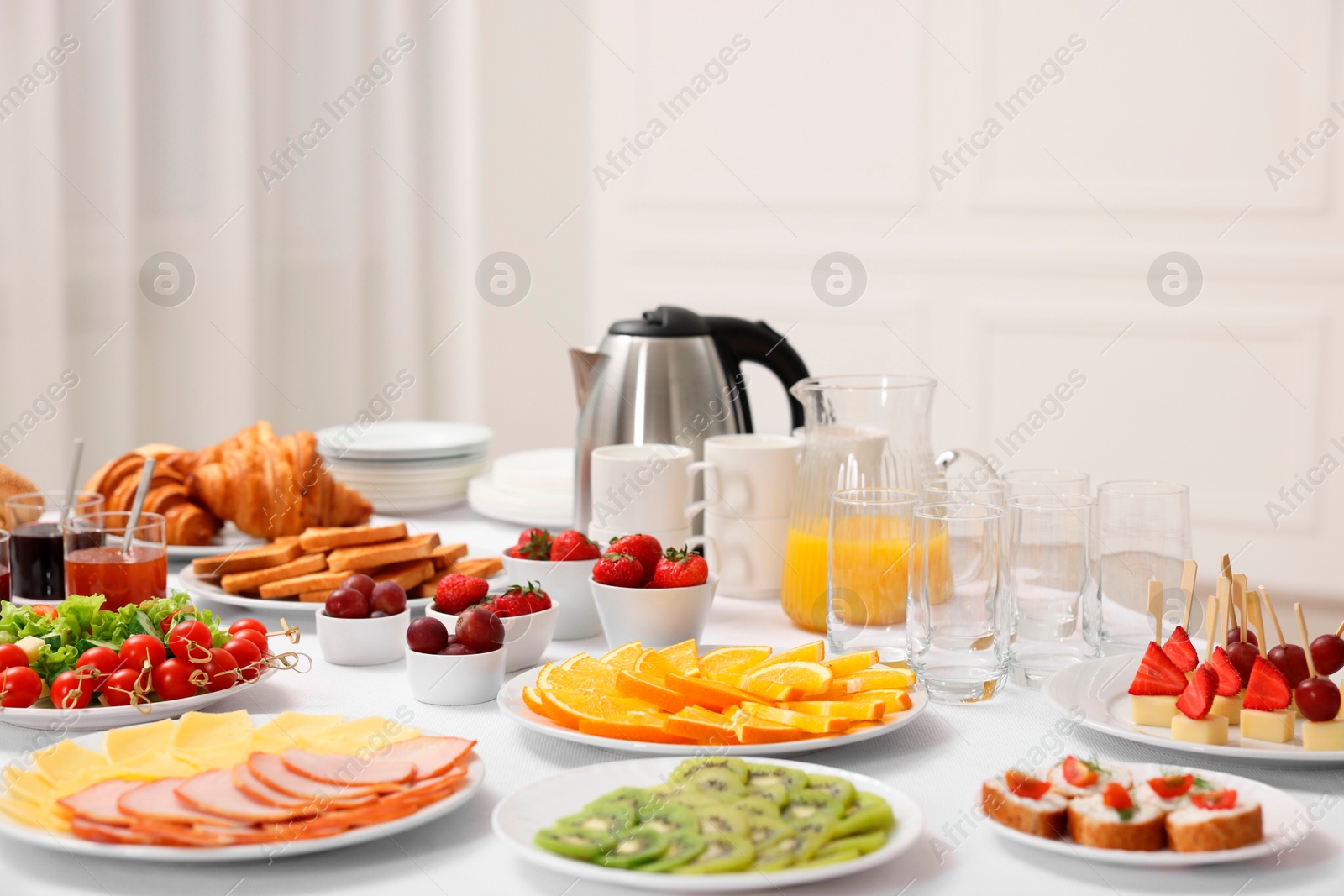 Photo of Different meals served on white table indoors. Buffet menu