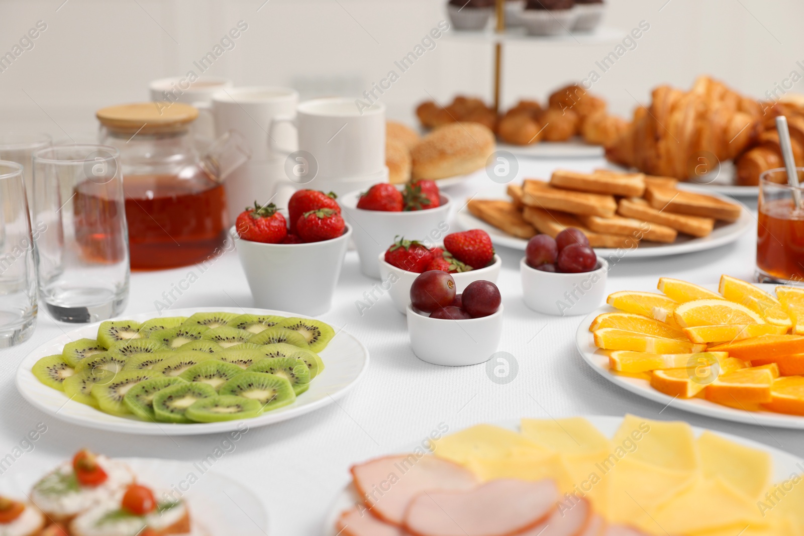 Photo of Different meals served on white table indoors, selective focus. Buffet menu