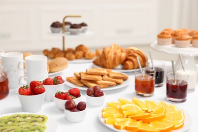 Different meals served on white table indoors. Buffet menu