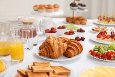 Different meals served on white table indoors. Buffet menu