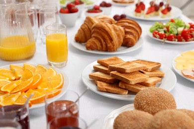 Different meals served on white table indoors, selective focus. Buffet menu