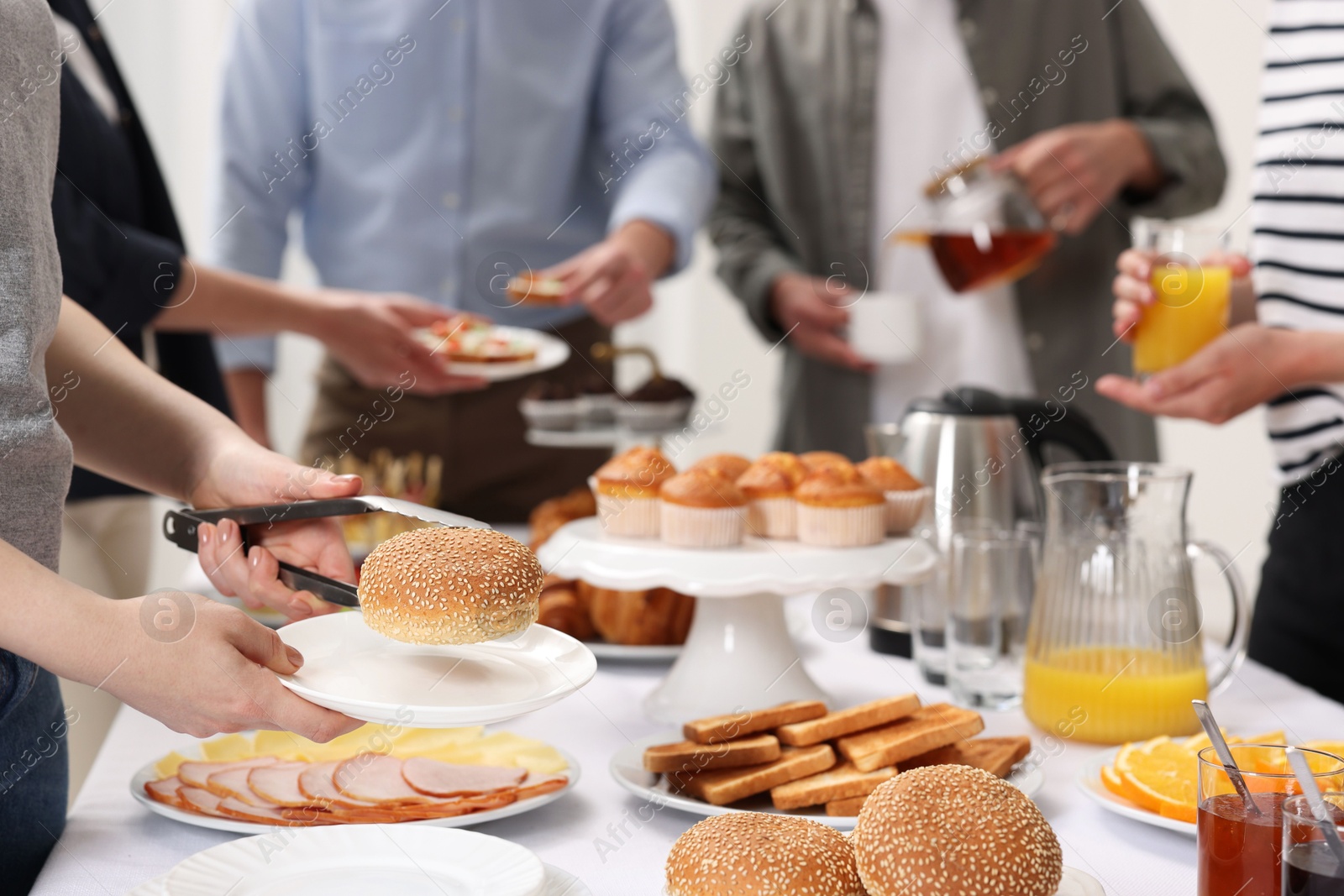 Photo of Coworkers having business lunch at white table indoors, closeup