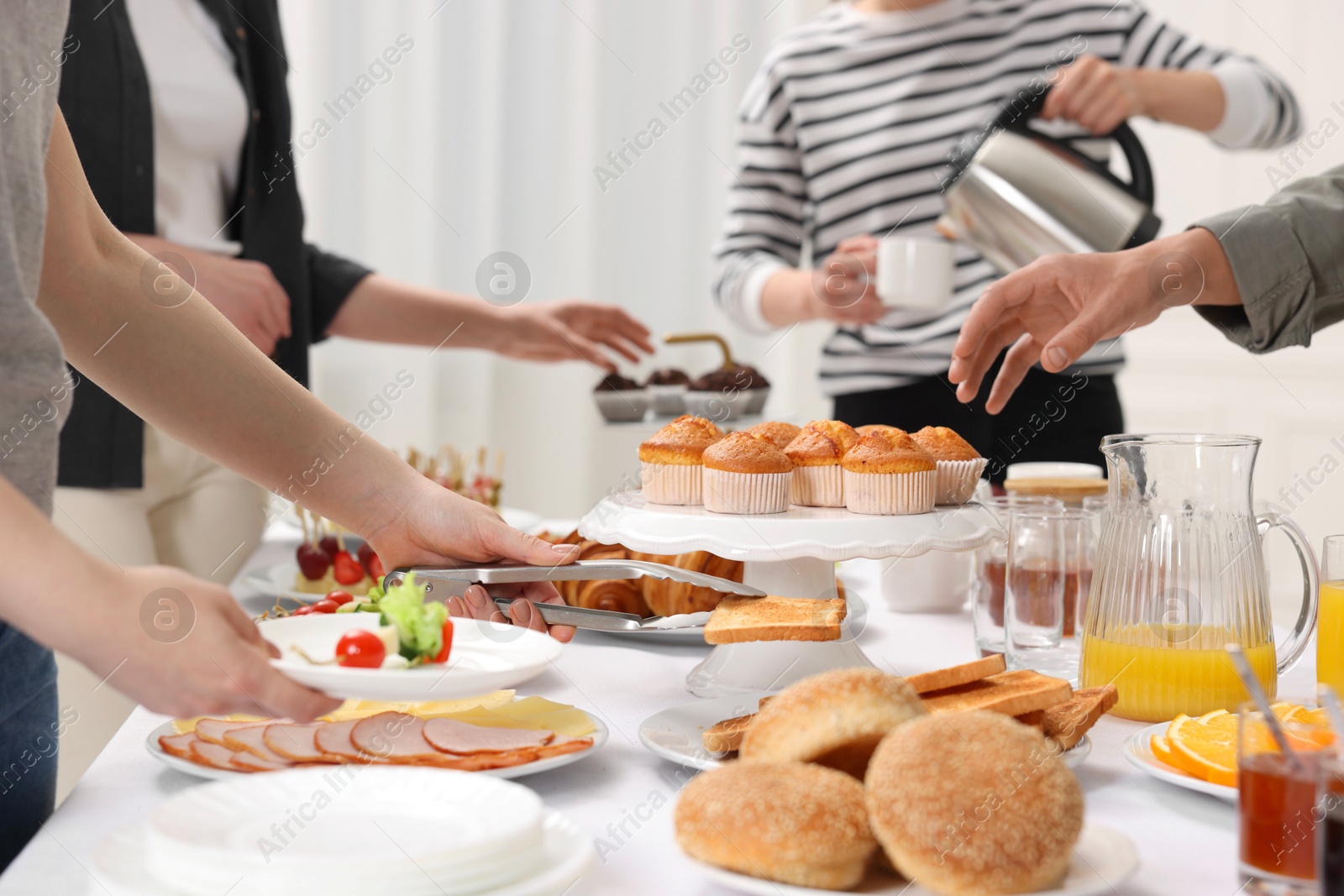 Photo of Coworkers having business lunch at white table indoors, closeup