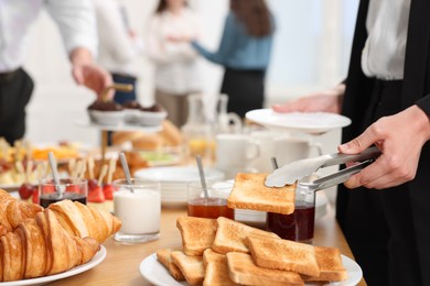 Coworkers having coffee break in office, closeup