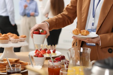 Coworkers having coffee break in office, closeup