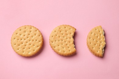 Tasty sandwich cookies on pink background, top view