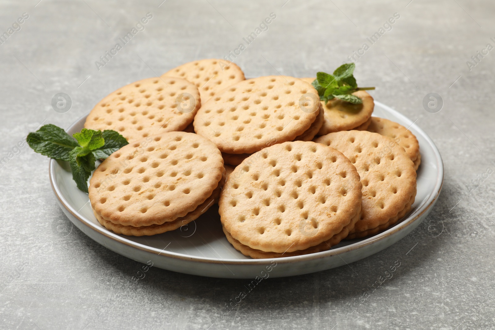 Photo of Tasty sandwich cookies on light gray textured table, closeup