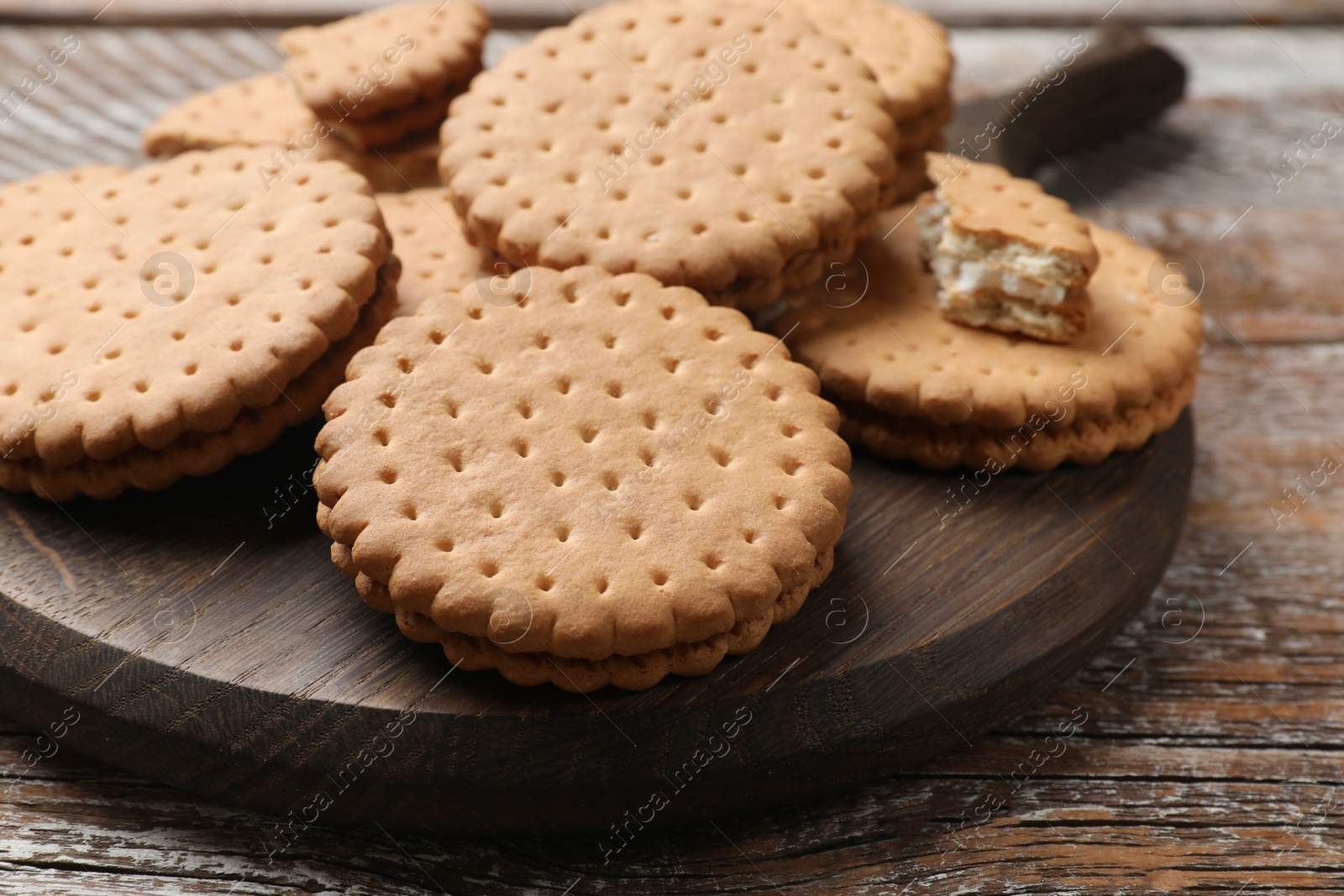 Photo of Tasty sandwich cookies on wooden table, closeup