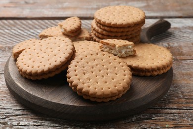 Photo of Tasty sandwich cookies on wooden table, closeup