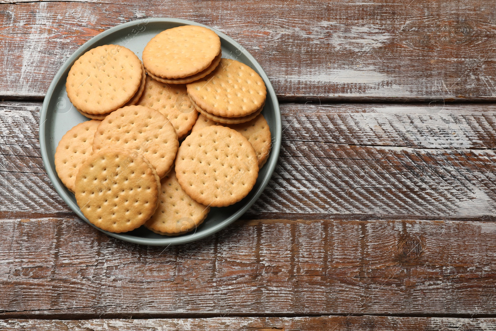 Photo of Tasty sandwich cookies on wooden table, top view. Space for text