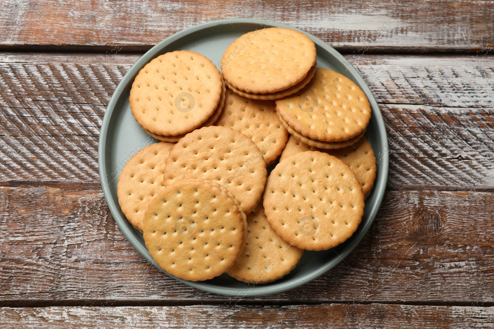 Photo of Tasty sandwich cookies on wooden table, top view