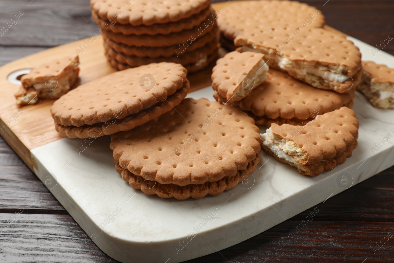 Photo of Tasty sandwich cookies on wooden table, closeup