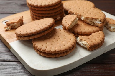 Tasty sandwich cookies on wooden table, closeup