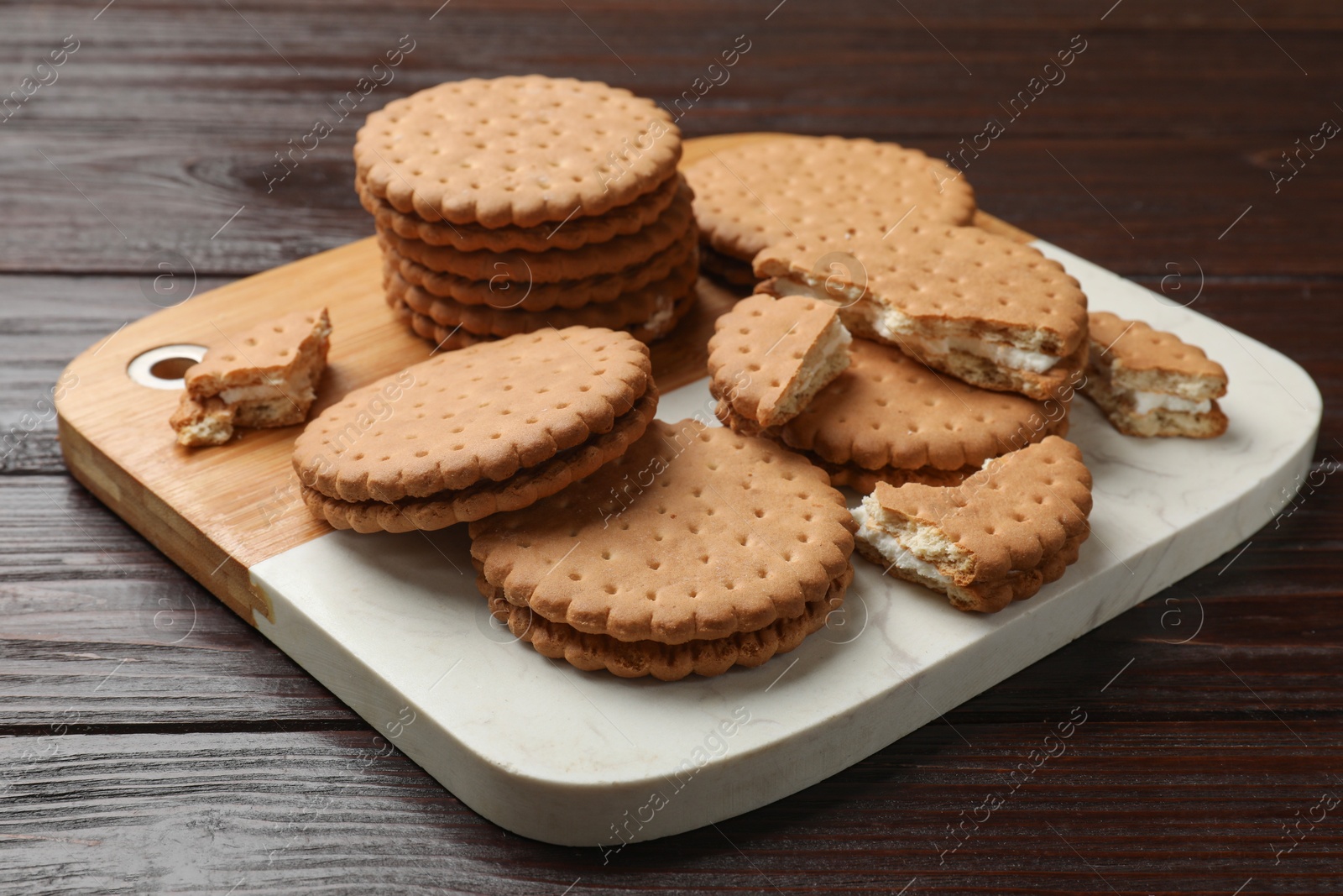 Photo of Tasty sandwich cookies on wooden table, closeup