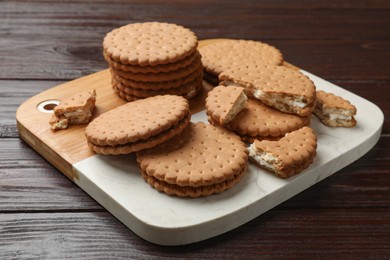 Tasty sandwich cookies on wooden table, closeup