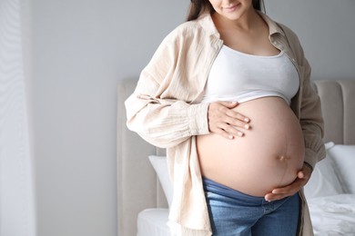 Photo of Pregnant woman at home, closeup. Space for text