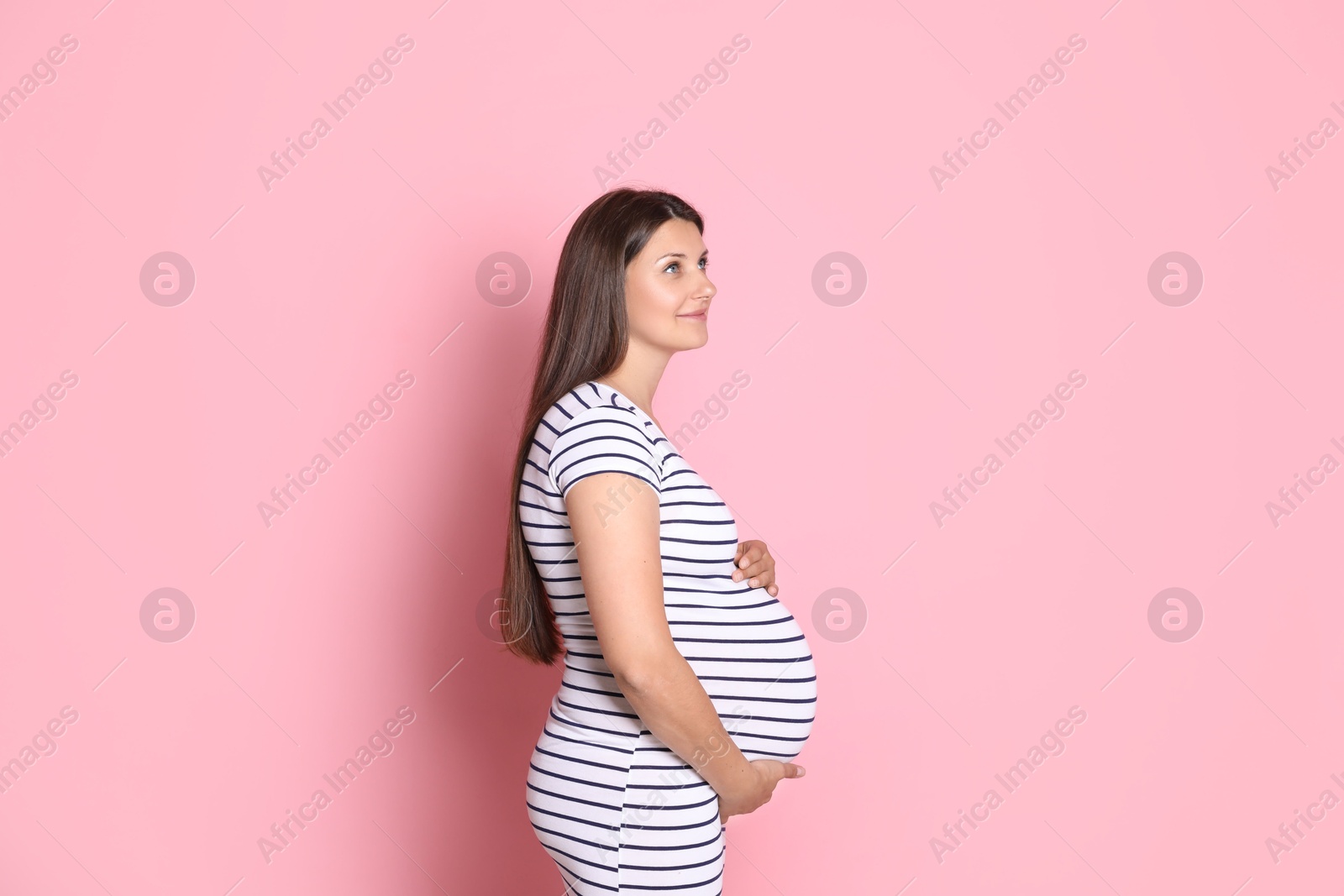 Photo of Portrait of beautiful pregnant woman on pink background