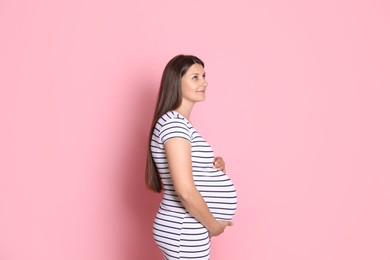 Photo of Portrait of beautiful pregnant woman on pink background