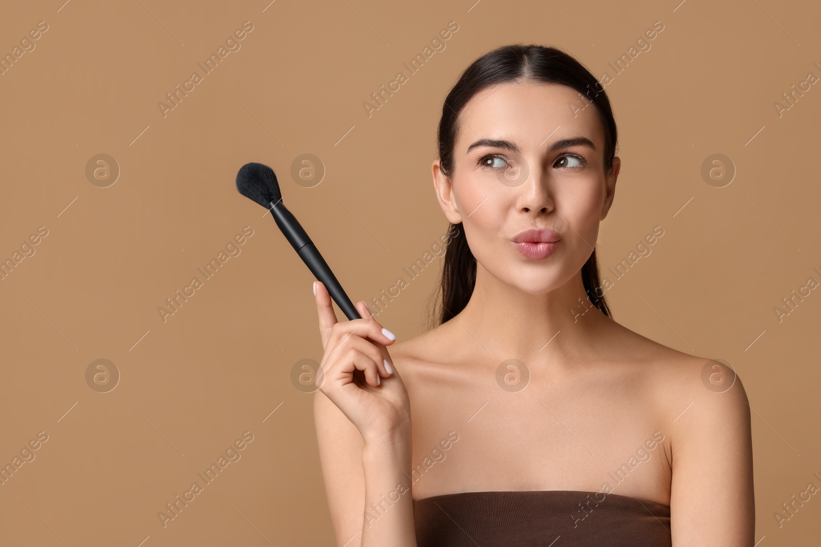 Photo of Beautiful makeup. Attractive woman with brush on beige background, space for text