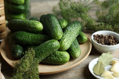 Fresh cucumbers and spices on wooden table, closeup. Preparation for pickling